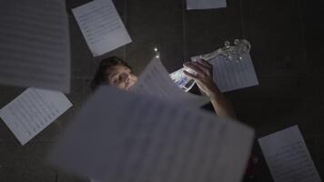 Sheets of paper fall on the lying violinist video