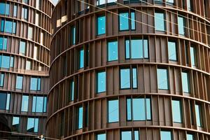 Architectural detail of modern office buildings with rounded architecture and pattern of windows reflecting blue sky. Contemporary minimalist architecture photo