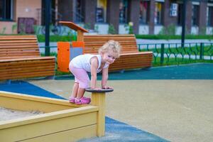 Child playing in the sandbox in the playground in the courtyard of a house photo