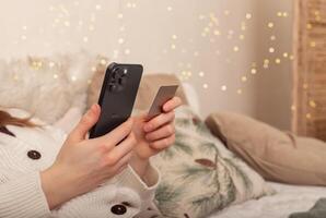 Lodz Poland July 20 2024, hands holding and using mobile phone, iphone smartphone on Christmas photo