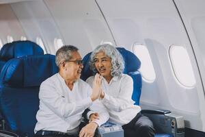 A mature couple enjoys a plane ride sitting near the window. They looked out into the sky. Immerse yourself in the scenery and excitement of the journey. To create precious memories together photo