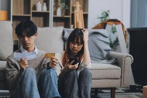Worried annoyed young husband wife using phone credit card dissatisfied with interrupted wifi internet connection slow bad app work. Angry family couple bank clients unable to pay online check balance photo