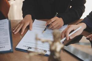 Lawyer, legal advisor, businessman brainstorming information on agreement details Business contracts in legal processing books for accuracy in contract documents. joint financial investment. photo