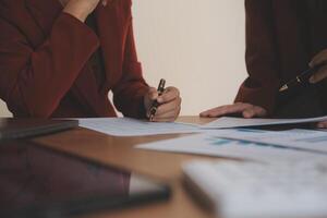 Group of confident business people point to graphs and charts to analyze market data, balance sheet, account, net profit to plan new sales strategies to increase production capacity. photo