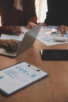 Group of confident business people point to graphs and charts to analyze market data, balance sheet, account, net profit to plan new sales strategies to increase production capacity. photo