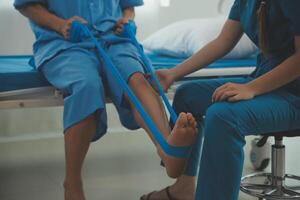 Physical therapists work with patients in close-up clinics. The concept of rehabilitation of physical health, the doctor gives advice to the patient. Ankle problems and muscle injuries photo