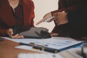 Group of confident business people point to graphs and charts to analyze market data, balance sheet, account, net profit to plan new sales strategies to increase production capacity. photo