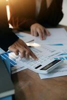 Group of confident business people point to graphs and charts to analyze market data, balance sheet, account, net profit to plan new sales strategies to increase production capacity. photo