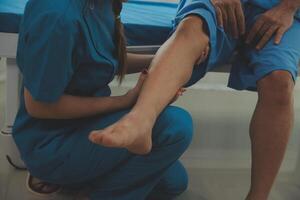 Physical therapists work with patients in close-up clinics. The concept of rehabilitation of physical health, the doctor gives advice to the patient. Ankle problems and muscle injuries photo