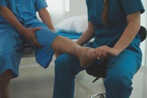 Physical therapists work with patients in close-up clinics. The concept of rehabilitation of physical health, the doctor gives advice to the patient. Ankle problems and muscle injuries photo