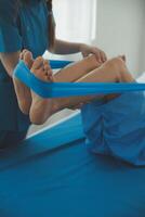 Physical therapists work with patients in close-up clinics. The concept of rehabilitation of physical health, the doctor gives advice to the patient. Ankle problems and muscle injuries photo