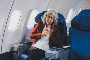 Mature with headache with nausea feeling sick while sitting in the airplane , Passengers near the window. photo