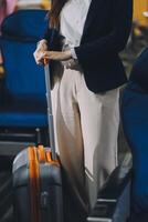 Businesswoman, confident tourist walks with suitcase, checks seat, flight number, puts her suitcase on shelf inside airplane travel lifestyle concept. photo