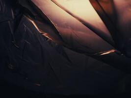 Dark brown plastic bag in lights at night for background about environmental issues. photo