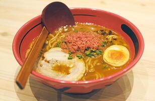 Japanese ramen noodles with pork, seaweed, soup in red bowl photo