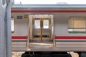 Jakarta, Indonesia, 2024 - Side view of a commuter line train platform in Jakarta with the doors open. photo