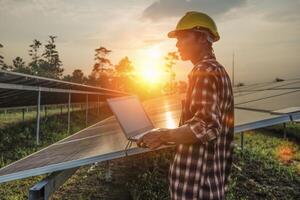 Male engineer working at high level to check efficiency of solar cell from clean solar cell which is friendly to environment. photo