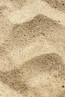 Fine sand at a beach background. Subtle patterns and textures under soft sunlight. photo