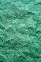Crumpled green paper texture with varying shades and deep folds. Abstract background. photo