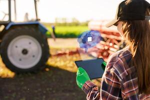 A farmer with a tablet successfully uses artificial intelligence at an agribusiness, with a farmer's field in the background photo