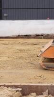 Vertical Footage of Worker Using Plate Compactor to Compact Sand. Asphalt Pavement Installation Process video