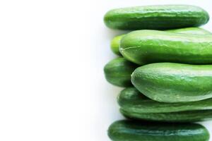 Isolated Heap of green Cucumbers, group of fresh cucumbers on the white background. Close-up, top view, macro, copy space photo