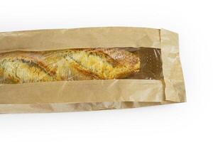 Freshly baked French baguette in a brown paper bag isolated on a white background.Loaf of white bread wrapped in eco-friendly sustainable brown paper bag. Copy space. With clipping path. photo