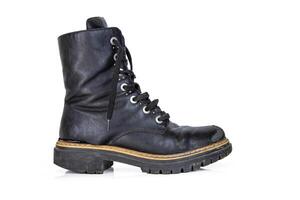 One black worn ankle leather combat boot with thick, sturdy sole and laces. Single vintage military style shoe. Studio light. Isolated on white background. Empty copy space. Clipping path photo