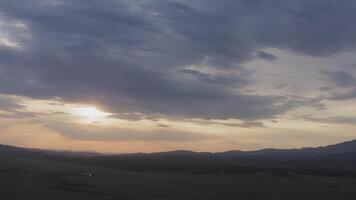 Drone view of a sunset in a valley with a river and mountain ranges video