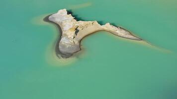 Drone view of the turquoise lake formed as a result of mining waste video
