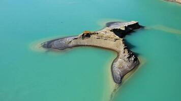 Aerial view of the turquoise lake formed as a result of mining waste video