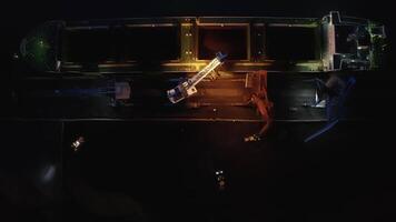 View from a drone vertically down to cargo cranes working in the port at night video