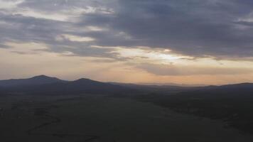 Drone view of a sunset in a valley with a river and mountain ranges video