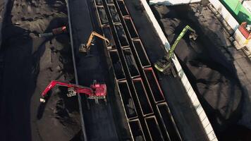 Excavators unloading coal from a cargo train. video