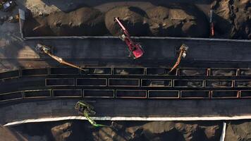 Excavators unloading coal from a cargo train. video