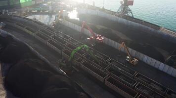 Excavators unloading coal from a cargo train. video