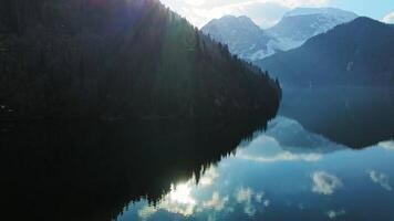 Clear blue mountain lake with reflection of clouds on the water. Drone view video