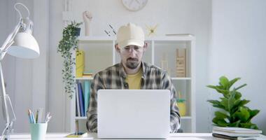 milenar trabalhador autonomo trabalhando em computador escrivaninha remotamente a partir de casa telefone chamar. video