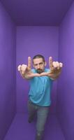 Young handsome man doing frame using hands palms and fingers, over purple background video