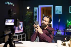 Tech specialist filming review of portable V mount battery in home studio using professional camera. Man recording unboxing of lithium li-ion charging gadget using specialized gear photo