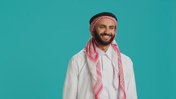 Young arab guy saying yes and nodding in studio, showcasing agreement and his support about something. Middle eastern adult expressing positivity and happiness, approving and accepting. photo