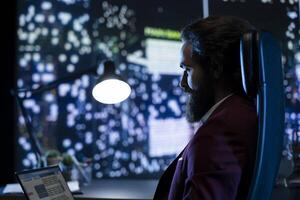 Skilled administrator researches global market to boost legal revenue worldwide and manage resources for investment. Professional working after hours to secure necessary funding. photo