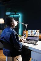 African American woman having a call with colleagues while working remotely from her apartment. They are engaged in a discussion and utilizing technology for virtual communication. photo