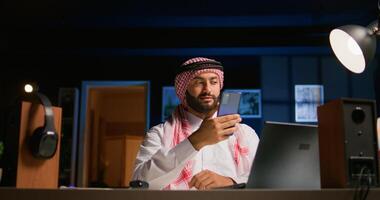 Arab man checking up on close friend during conference meeting over the internet. Middle Eastern person enjoying time together with friend in online call session while at home photo