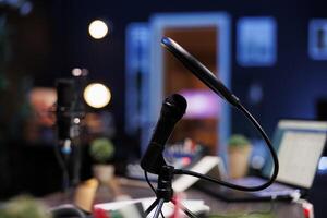 Closeup of a professional microphone with condenser filter in an empty vlog broadcasting studio being used to record social media content. Detailed view of audio live broadcast digital microphone. photo