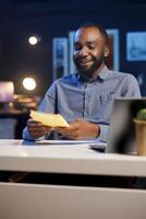 Smiling BIPOC content creator films review of book, browsing through pages, presenting synopsis to audience. Online star sponsored by publisher to show new novel release to readers photo