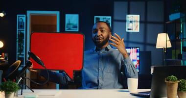 African american man filming sponsored content, holding empty copy space sign, following script while talking to audience. Online star using cardboard bubble speech cutout to do influencer marketing photo