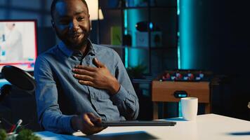 African american content creator filming technology review of newly released laptop, unpacking it and presenting specifications to audience. Influencer showing notebook to viewers photo