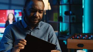 African american content creator filming technology review of newly launched tablet, unpacking it and presenting specifications to audience. Media star showing device to viewers photo