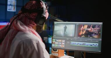 Middle Eastern content creator editing cinematographic project in post production process, working with images and sounds. Teleworking artist doing selection on computer screen photo